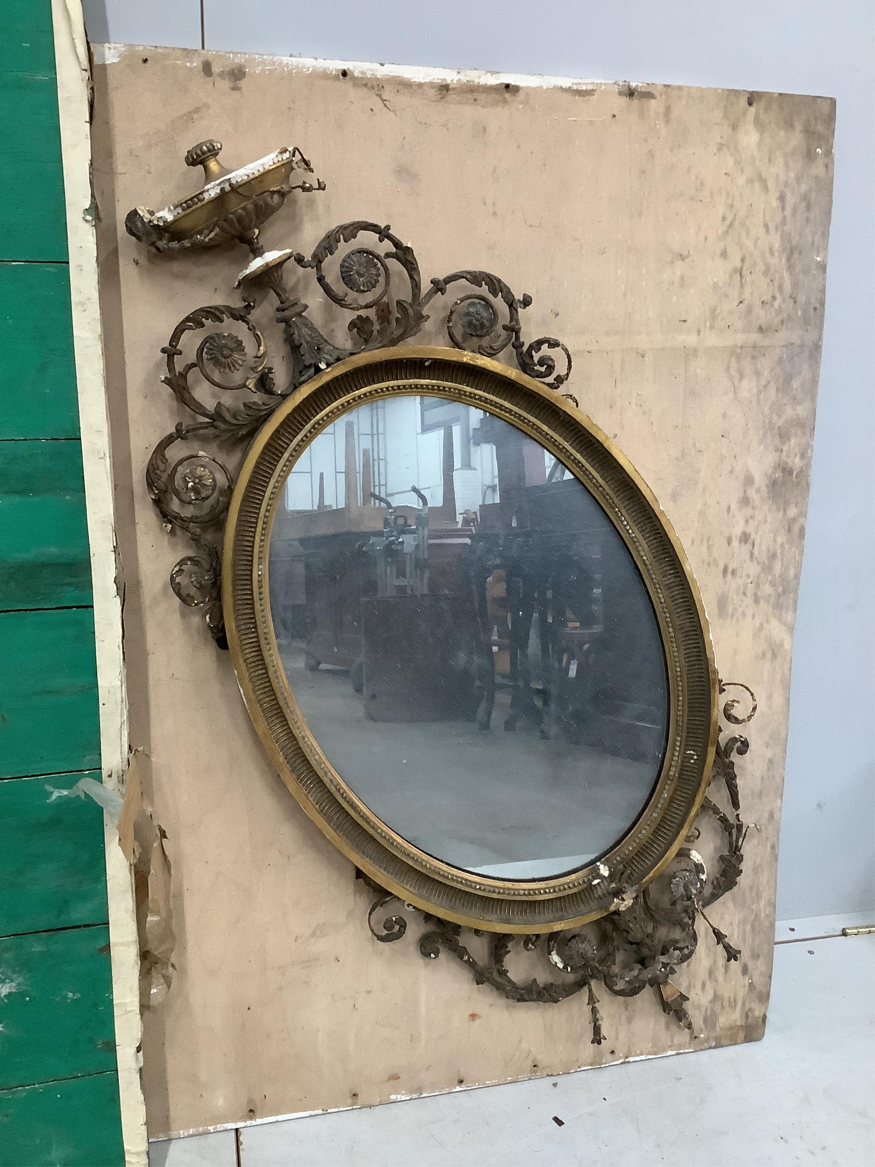 Two late Victorian / Edwardian Sheraton Revival oval giltwood and composition wall mirrors, larger width 100cm, height 95cm. Condition - poor to fair